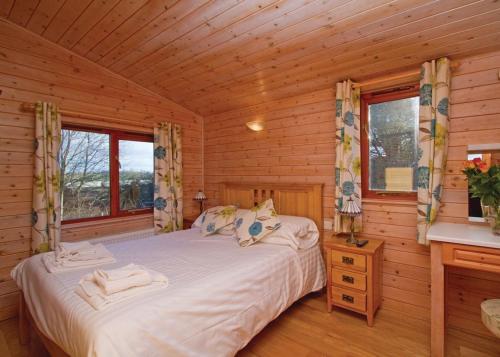una camera con un letto in una baita di tronchi di Nunland Hillside Lodges a Holywood