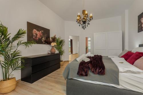a bedroom with a large bed and a chandelier at LoC - Oldenburg Altstadtlage in Oldenburg