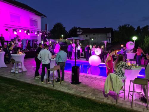 un gruppo di persone a una festa a bordo piscina di notte di Villa Mia a Prnjavor