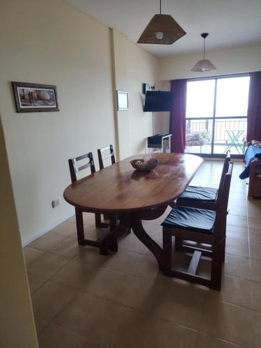 una mesa de madera y sillas en la sala de estar. en Namalu3 en Puerto Madryn