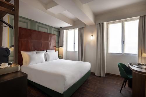 um quarto de hotel com uma grande cama branca e janelas em Maison Roma Piazza di Spagna UNA Esperienze em Roma