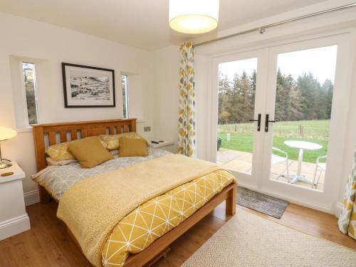 een slaapkamer met een bed en een glazen schuifdeur bij Woodland View in Bishop Auckland