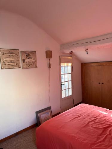 - une chambre avec un lit rouge et une fenêtre dans l'établissement Face à la mer, à Bandol