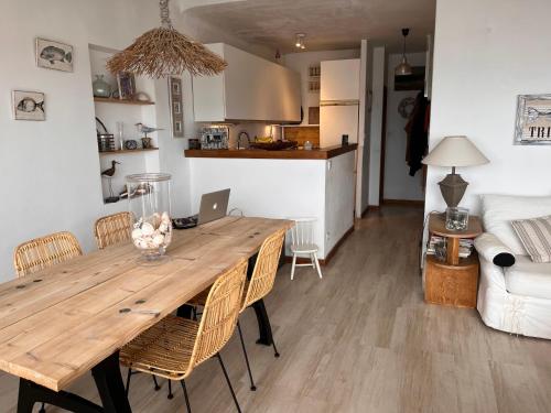 Il dispose d'une cuisine et d'un salon avec une table et des chaises en bois. dans l'établissement Face à la mer, à Bandol
