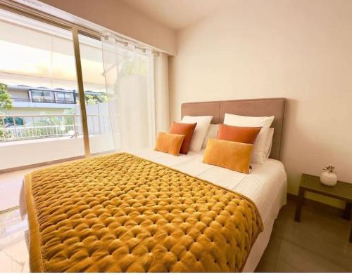 une chambre avec un grand lit avec des oreillers orange dans l'établissement Sweet home+terrasse de 60m2 ,2 mn from croisette beach, à Cannes