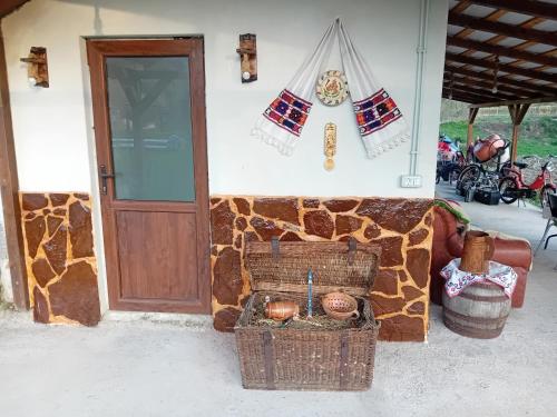 a building with a stone wall with baskets and a door at Casa Eva in Bucureşci