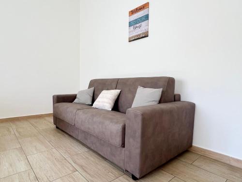 a brown couch sitting against a white wall at Come a Casa Tua in Sassari