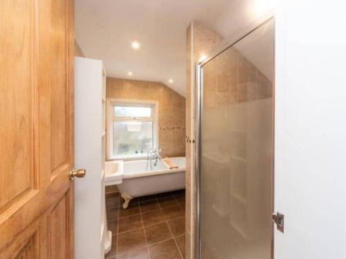 a bathroom with a bath tub and a sink at Charming Period Home near Surbiton with Garden in London