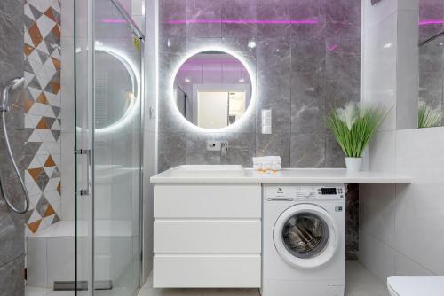 a bathroom with a washing machine and a mirror at Modern Apartment With Private Garden Międzywodzie by Renters Prestige in Międzywodzie