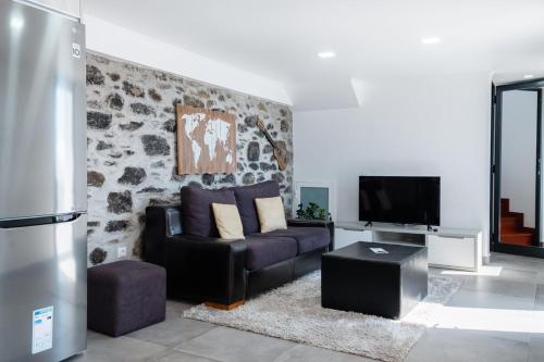 a living room with a couch and a tv at GuestReady - Leme Beach Breathtaking Views in Gaula