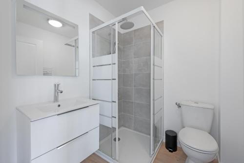a white bathroom with a toilet and a shower at T2 avec parking gratuit - proximité gare in Toulouse