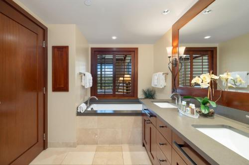 a bathroom with two sinks and a large mirror at Ko Olina Beach Villas O805 in Kapolei