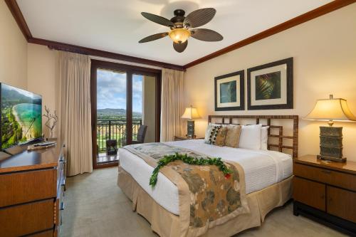a bedroom with a bed and a tv and a window at Ko Olina Beach Villas O805 in Kapolei