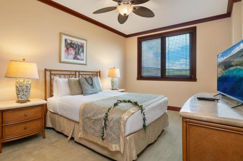 a bedroom with a bed and a dresser with a television at Ko Olina Beach Villas O805 in Kapolei