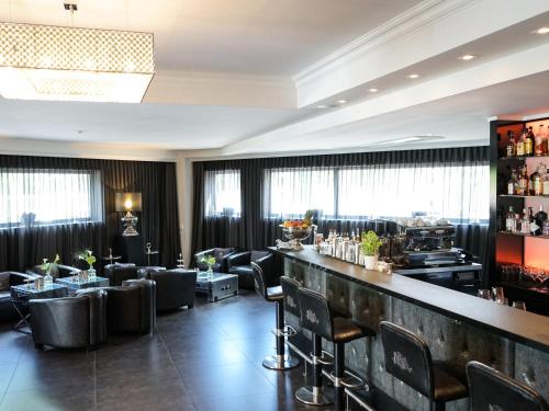 a bar in a restaurant with chairs and a counter at Villahotel Rheinblick in Cologne