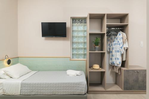 um quarto com uma cama e uma televisão na parede em Stefanie Studios em Agia Marina Nea Kydonias