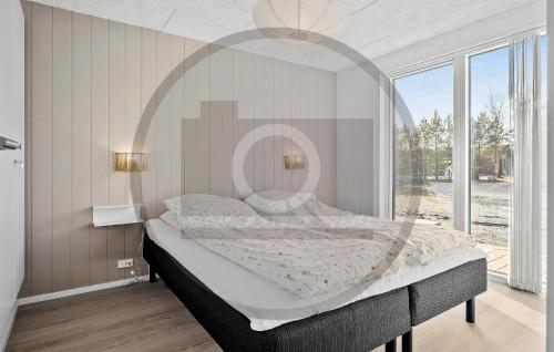 4 Bedroom Amazing Home In Hals في هالس: غرفة نوم بسرير كبير ونافذة كبيرة
