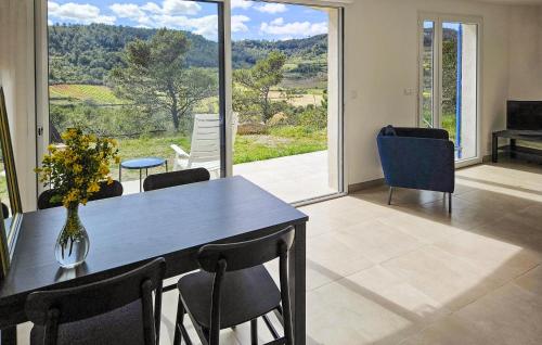 une salle à manger avec une table et des chaises et une grande fenêtre dans l'établissement 3 Bedroom Gorgeous Home In Pierrerue, à Pierrerue