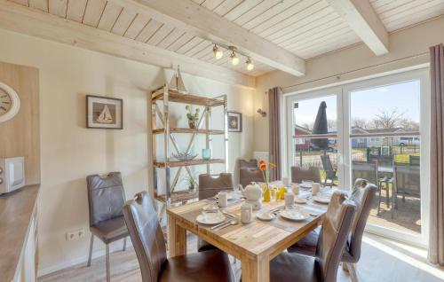 a dining room with a table and chairs and a window at Stunning Home In Dagebüll With Sauna in Dagebüll