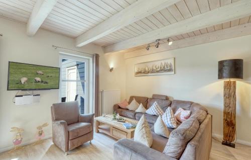 a living room with a couch and a chair at Stunning Home In Dagebüll With Sauna in Dagebüll