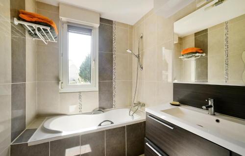 ein Bad mit einer Badewanne, einem Waschbecken und einem Fenster in der Unterkunft Cozy Apartment In La Grande-motte With Lake View in La Grande-Motte