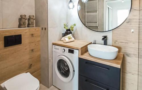 a bathroom with a washing machine and a sink at 2 Bedroom Beautiful Apartment In Biskupiec in Biskupiec