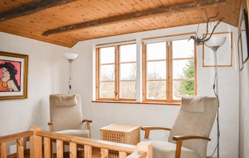 two chairs and a table in a room with windows at 2 Bedroom Nice Home In Fjälkinge in Fjälkinge