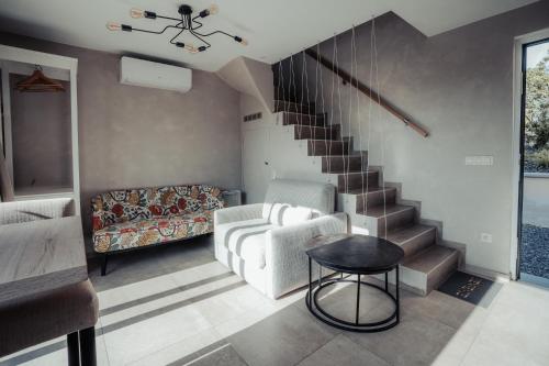 a living room with a staircase and a couch at MY House's - 3 maisons avec piscine commune et la maison pour 3 personnes max avec jacuzzi privé in Vinalmont