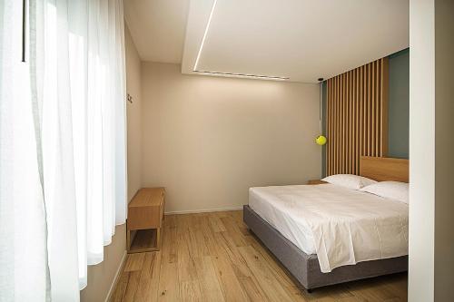 a bedroom with a bed and a large window at Giardino Delle Oche - Ocone Taburno Wine County in Ponte