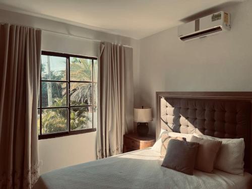 Un dormitorio con una cama grande y una ventana en Hacienda Ortiz: Luxury Space., en Matanzas