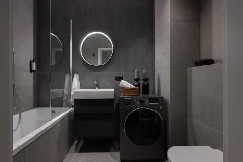 a bathroom with a washing machine and a sink at Scala Apartamenty by Moderna Profit- Łąkowa 60G z parkingiem in Gdańsk