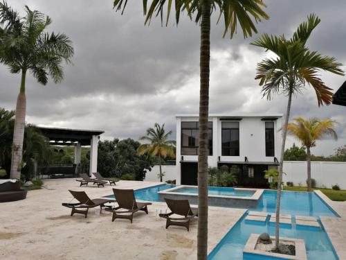 a villa with a swimming pool and palm trees at Hacienda Ortiz: Luxury Space. in Matanzas