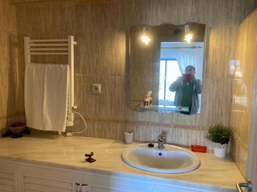 uma pessoa a tirar uma foto de um lavatório de casa de banho em LeComer em Carvoeiro