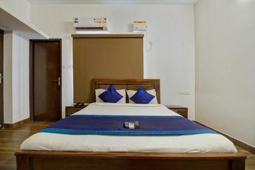 1 dormitorio con 1 cama grande con almohadas azules en Dakshin Stays en Chennai
