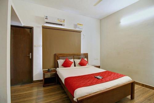 1 dormitorio con 1 cama con almohadas rojas en Dakshin Stays, en Chennai