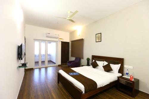 a hotel room with a bed and a tv at Dakshin Stays in Chennai