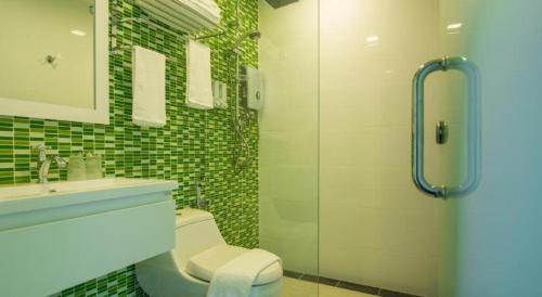 een badkamer met een douche, een toilet en een wastafel bij Riverfront Melaka Hotel in Melaka