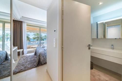 une chambre avec un lit et une salle de bain avec un lavabo dans l'établissement Cannes Superbe appartement Croisette 3 pieces, à Cannes
