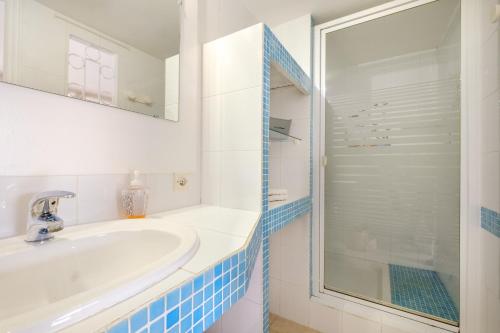 a white bathroom with a sink and a shower at Rez-de-villa avec piscine in Mandelieu-la-Napoule
