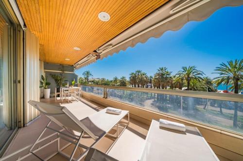 un balcon avec des chaises blanches et une vue sur l'océan dans l'établissement Cannes Superbe appartement Croisette 3 pieces, à Cannes