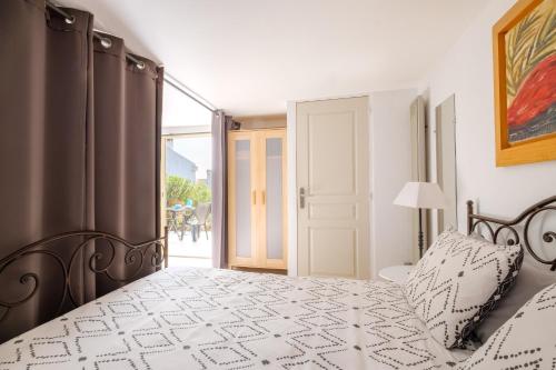 a bedroom with a bed and a door to a patio at Rez-de-villa avec piscine in Mandelieu-la-Napoule
