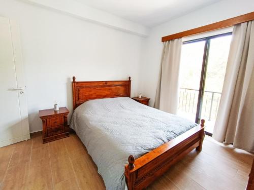 a bedroom with a bed and a large window at Maryloo Country House in Kakopetria