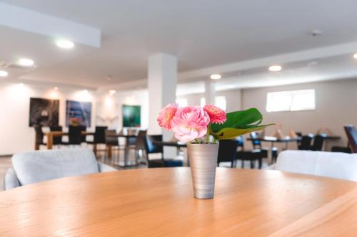 a vase with pink flowers sitting on a table at Remstal Hotel in Weinstadt