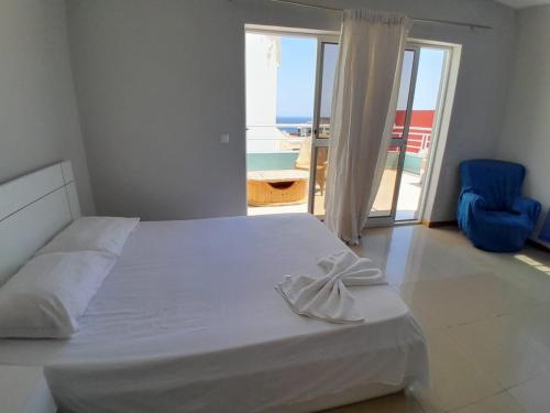 1 dormitorio con cama y vistas al océano en Praia Guest House en Praia