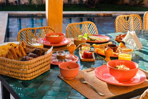 a table with a basket of bread and bowls of food at Villa DAR BOUMA in Ghazoua
