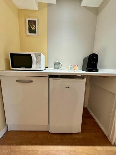 - un four micro-ondes installé sur un comptoir dans une pièce dans l'établissement Appartement lumineux et rénové près de Montmartre 