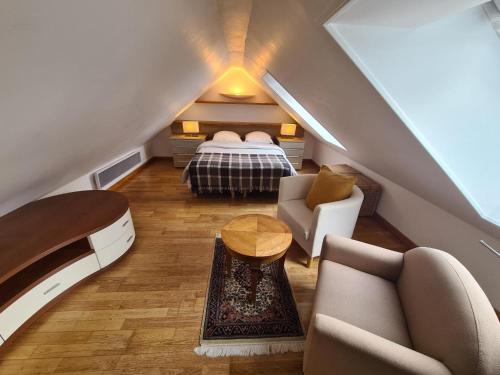 Cette chambre mansardée comprend un lit et un canapé. dans l'établissement Maison de charme au Vallon du Stang-Alar, à Brest