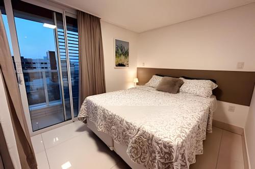 - une chambre avec un lit et une grande fenêtre dans l'établissement Apto 2Q com vista para o mar no Solar Tambaú, à João Pessoa