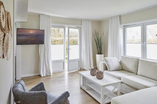 ein Wohnzimmer mit einem Sofa und einem Tisch in der Unterkunft Techts Sommerhaus in Timmendorfer Strand