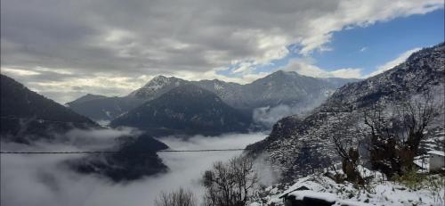 uma vista para uma serra com montanhas cobertas de neve em Agora Homestay em Uttarkāshi